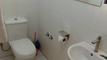 Ein Badezimmer mit Toilette, Waschbecken und Spiegel.