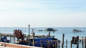 A waterfront area with boats docked, a pier, and a street lamp.