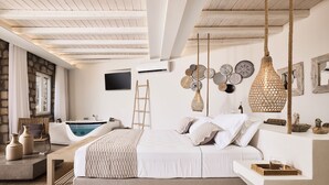 Una camera da letto con un letto grande, una scala in legno, una vasca e un televisore appeso al muro.