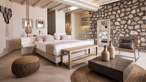 Una camera da letto con un letto, comodini, una panca di legno, un pouf intrecciato e un tavolino da caffè.