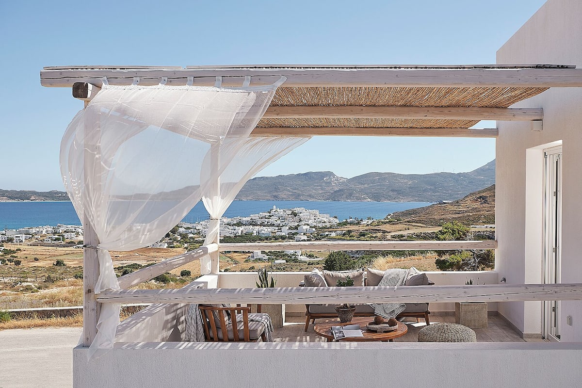 Un balcon avec vue sur la mer et un bâtiment blanc.