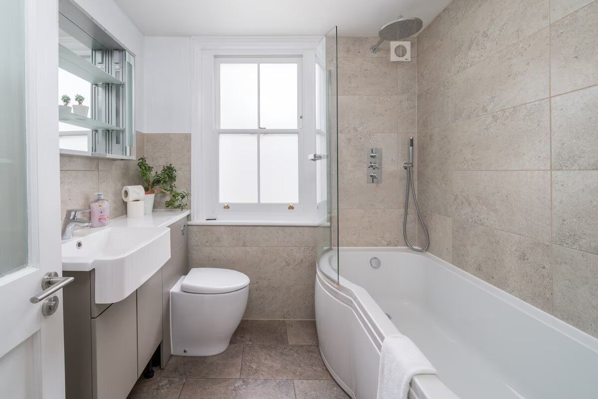 A modern bathroom with a toilet, sink, and bathtub.