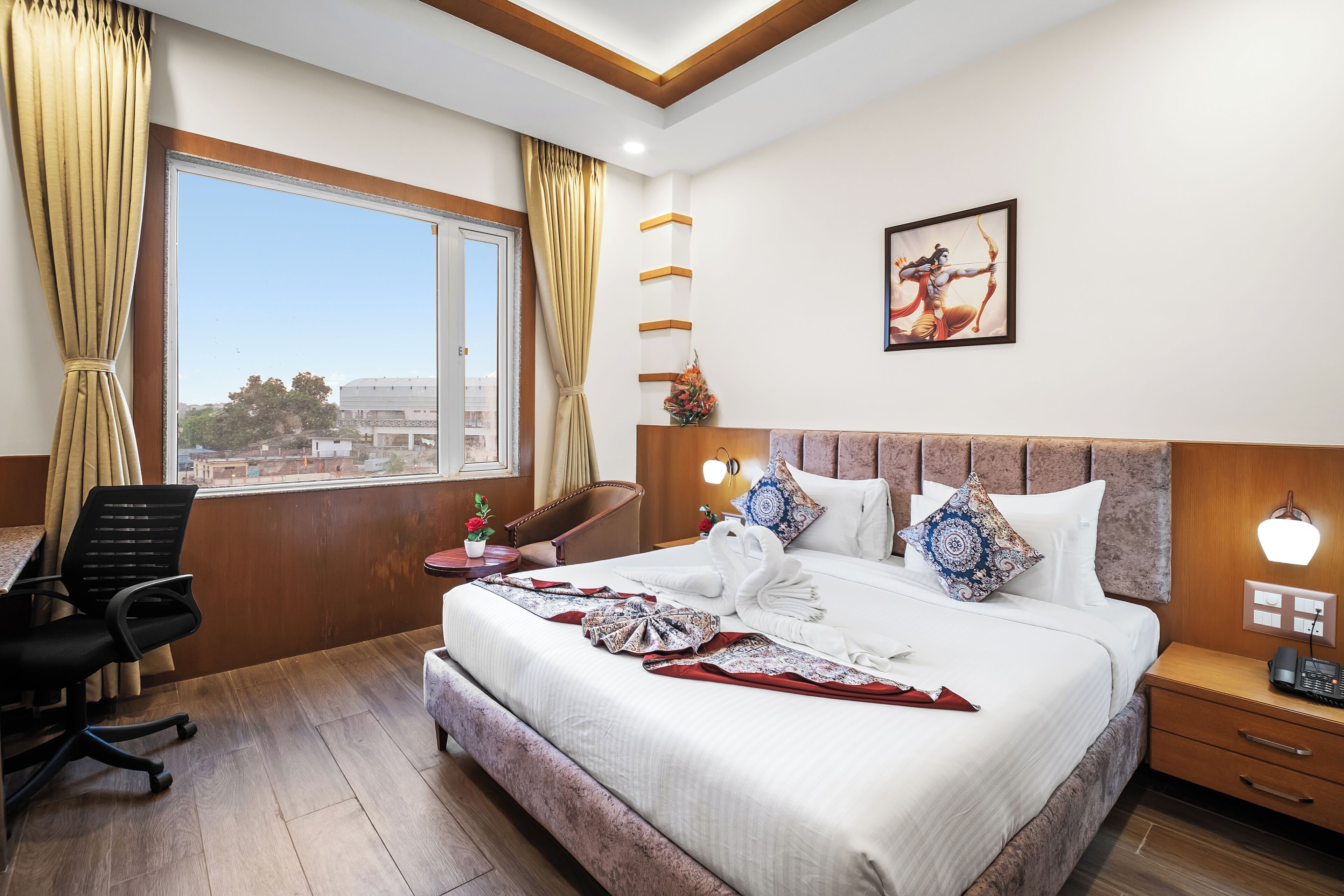 A hotel room with a large bed, a desk, and a chair.