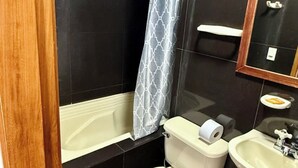A bathroom with a toilet, sink, and bathtub. - Apartahotel Montes  (Medellin)