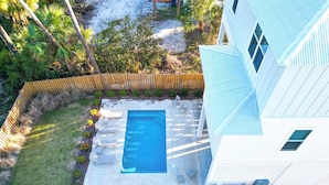 A residential property with a swimming pool, outdoor seating, and a fenced yard. - Watermark Way -Private pool- Elevator Private Beach access (Port St. Joe)