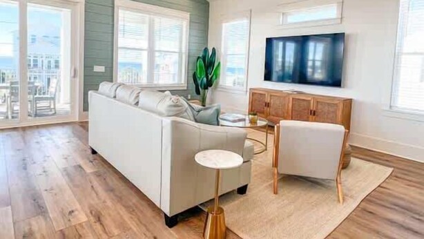 A modern living room with a sofa, a coffee table, and a TV on a wooden cabinet.