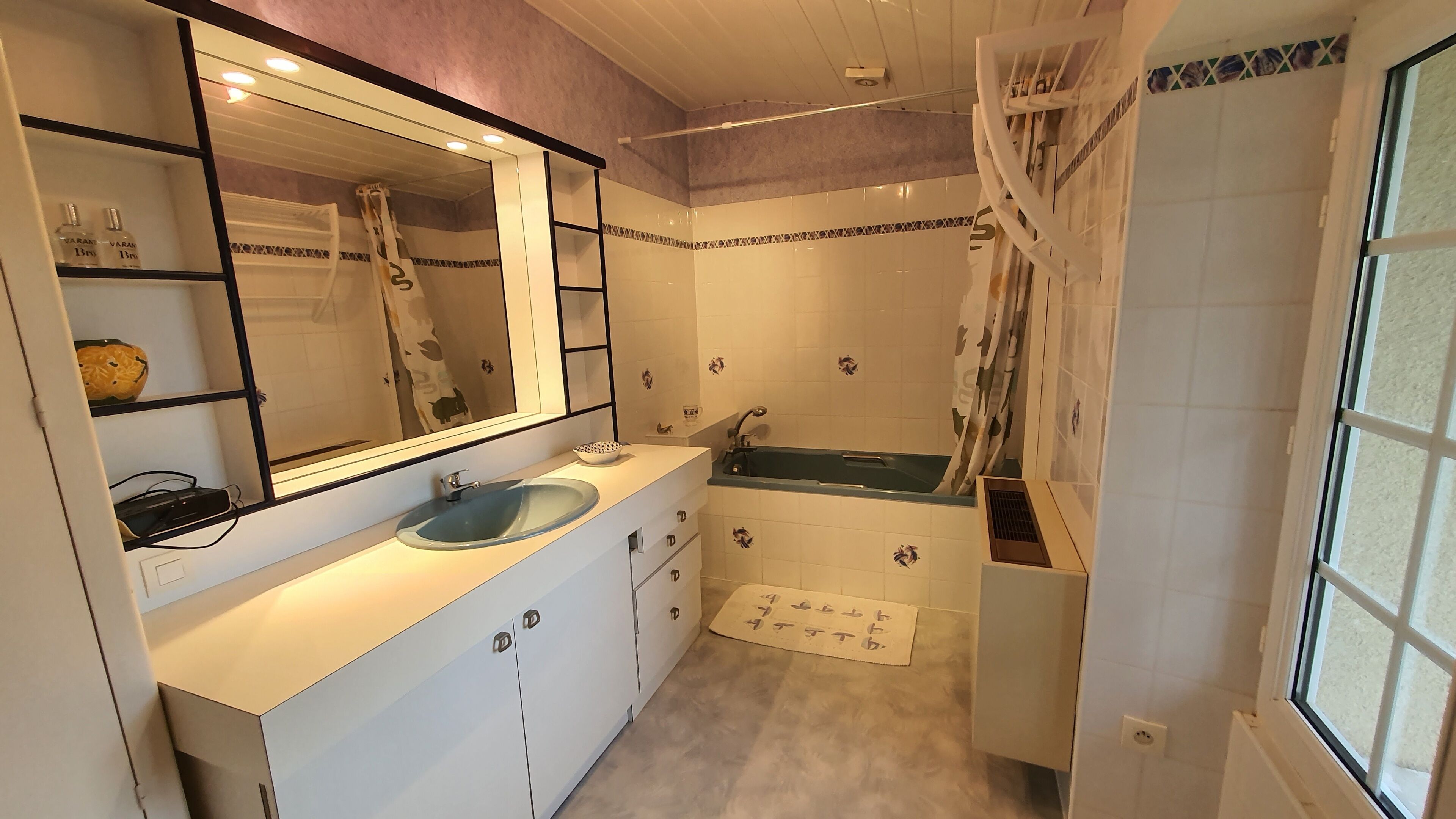 Un baño con lavamanos, espejo, bañera y ducha.