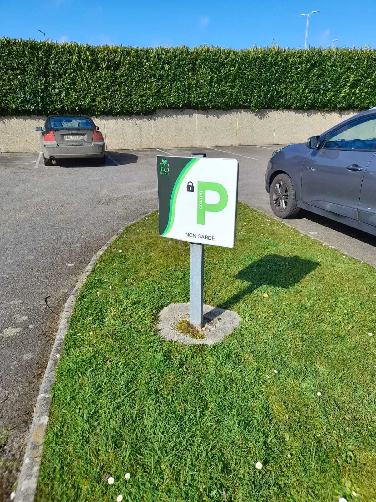 Un panneau de signalisation indiquant un parking avec un « P » vert et le texte « PARKING GRATUIT NON SURVEILLÉ », ce qui signifie que le stationnement est gratuit.