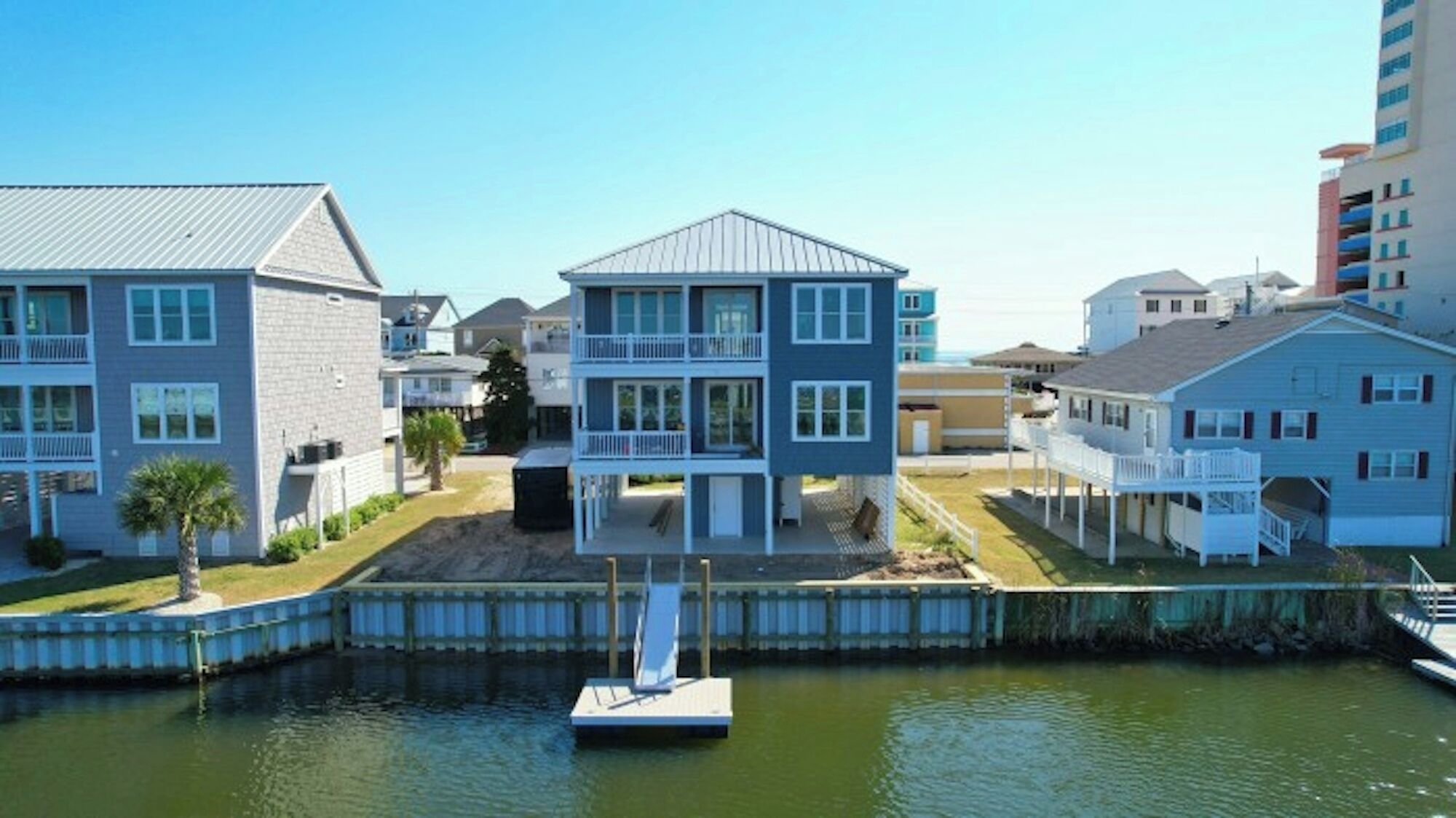 A waterfront property with two-story buildings, a dock, and a small boat.