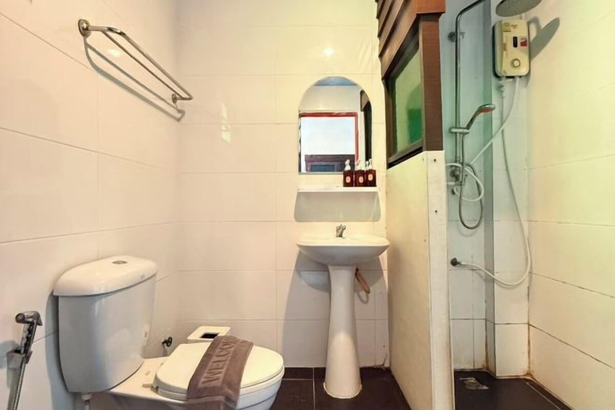 Un baño pequeño con inodoro, lavabo y ducha.