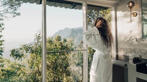 A room with a large window overlooking a mountainous landscape.