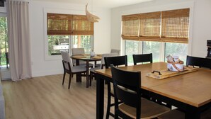 A dining area with a wooden table, black chairs, and a woven basket on the table. - The Maine Event- Wedding Weekend & Ski Getaways!  (Fryeburg)
