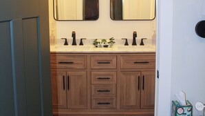 A bathroom with two sinks, wooden cabinets, and a mirror. - The Maine Event- Wedding Weekend & Ski Getaways!  (Fryeburg)
