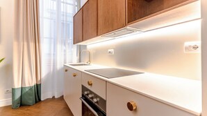 Eine moderne Küche mit Holzschränken, einer Edelstahlspüle und einem eingebauten Backofen.