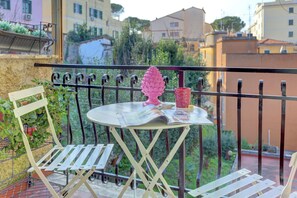 A balcony with a table, chairs, and a decorative item. - Vatican Loft with Balcony -Home and More (Rome)