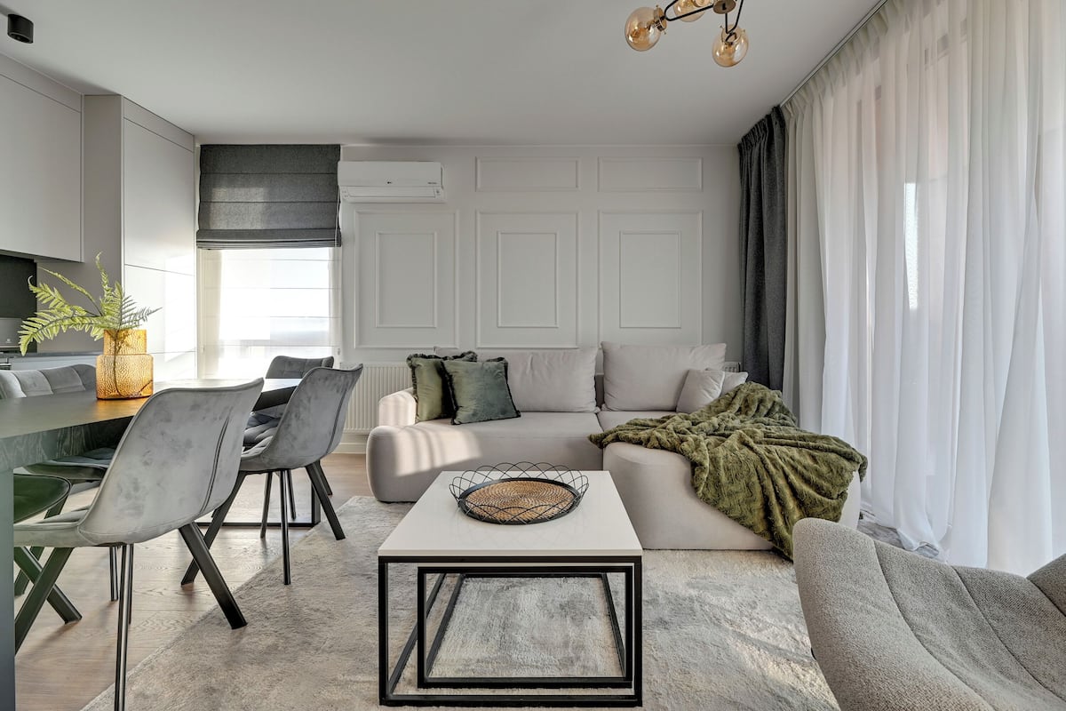 A modern living room with a dining area, a sofa, and a coffee table.