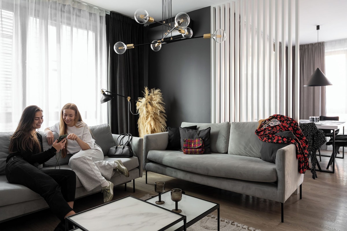 A modern living room with a grey sofa, a coffee table, and a decorative plant.