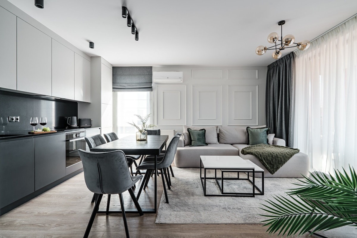 A modern kitchen with a dining area, a sofa, and a coffee table.