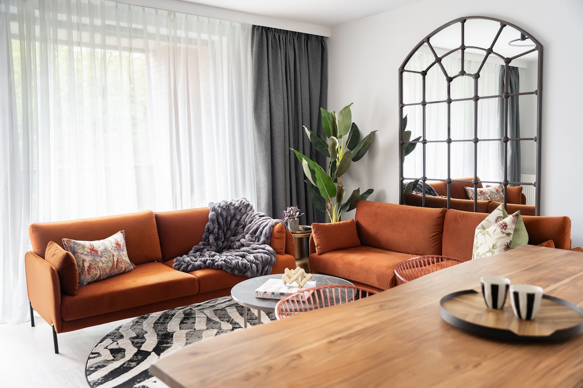A living room with a sofa, coffee table, and a large mirror.