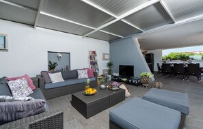 Un salon moderne avec un canapé, une table basse et un téléviseur à écran plat.