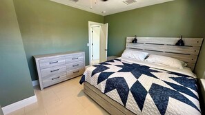 Une chambre à coucher avec un lit, une commode et une porte.