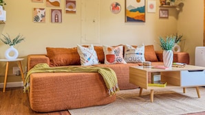 Una sala de estar acogedora con un sofá, una mesa de centro y decoración en la pared.