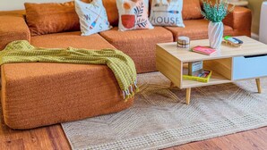 Una sala de estar acogedora con sofá, mesa de centro y decoración en la pared.