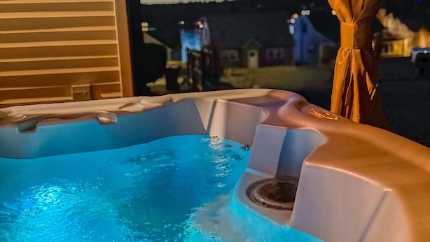 Un jacuzzi con vista a una zona residencial al anochecer.