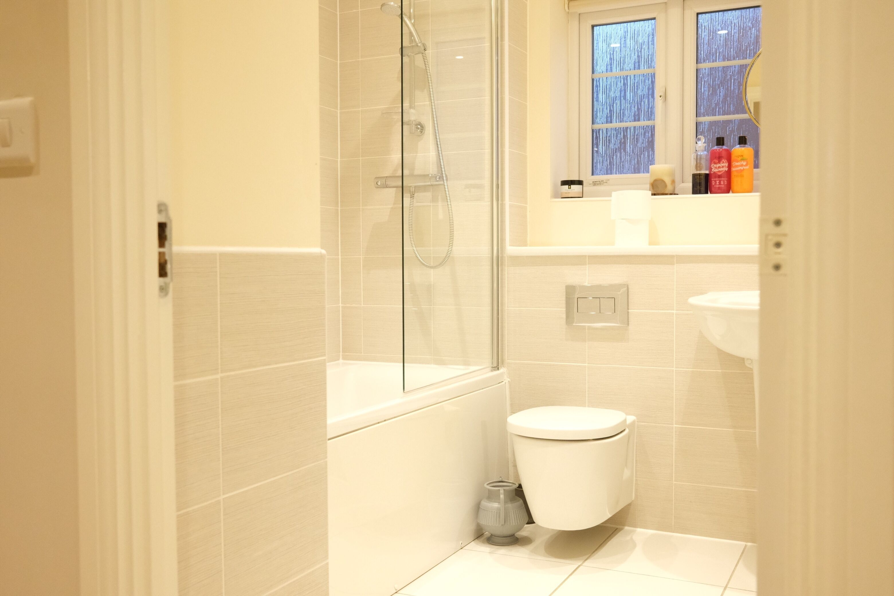 Une salle de bain moderne avec une douche à parois de verre, des toilettes blanches et un lavabo.
