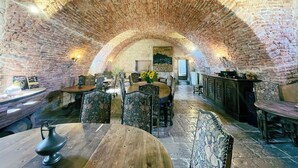 A rustic dining area with brick walls and wooden furniture. - Château de Goudourville 13th century, private, sleeps 30, swimming pool, reception area (Goudourville)