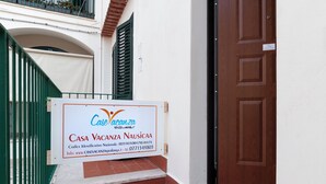 Placa de identificação da Casa Vacanza Nausea, com informações de contato e um site.
