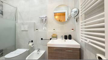 Un baño moderno con bidé, lavamanos, espejo y toallero.