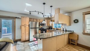 Una cocina moderna con una isla curva, electrodomésticos de acero inoxidable y muebles de madera.