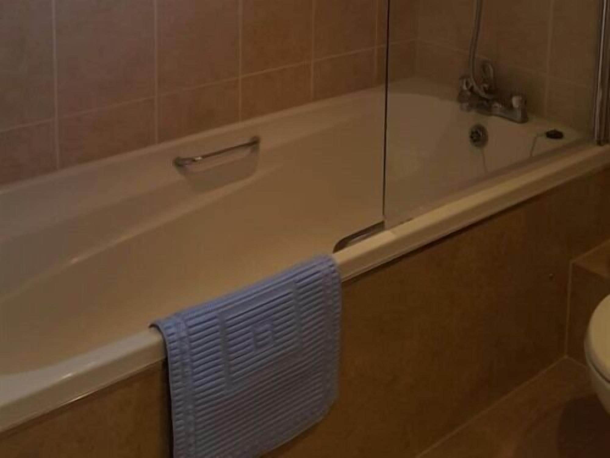 Une salle de bain avec une baignoire, une douche à parois de verre et des toilettes.