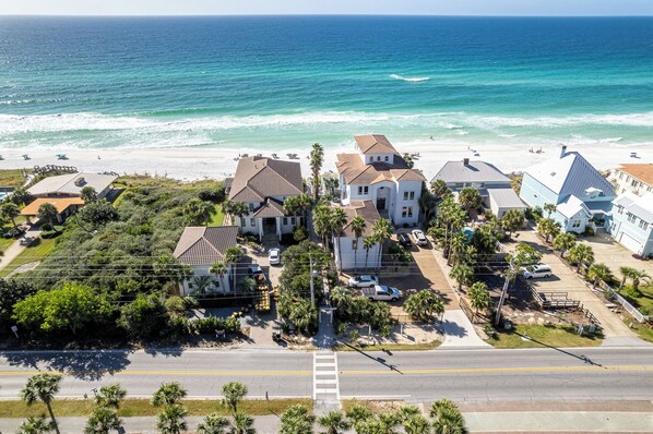 An aerial view of a coastal residential area with houses, a road, and the ocean. - Gulf Place 1B - Stylish condo, pool, tennis, deeded beach access!! (Santa Rosa Beach)