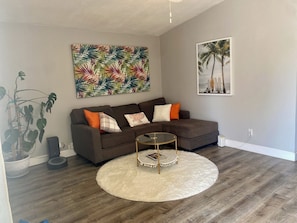 Relax in this stylish living room with a plush sofa, coffee table, and vibrant artwork.