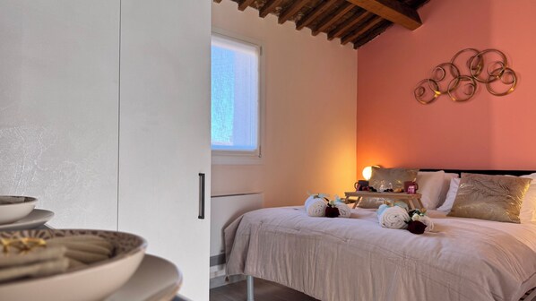 A bedroom with a bed, bedside table, and a window.