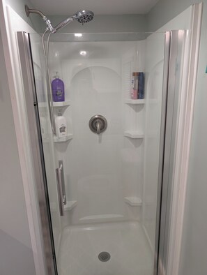 Een douche, handdoeken, zeep, toiletpapier