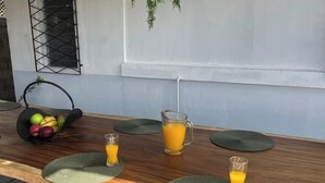Een ontbijttafel met fruit, sap en een karaf.