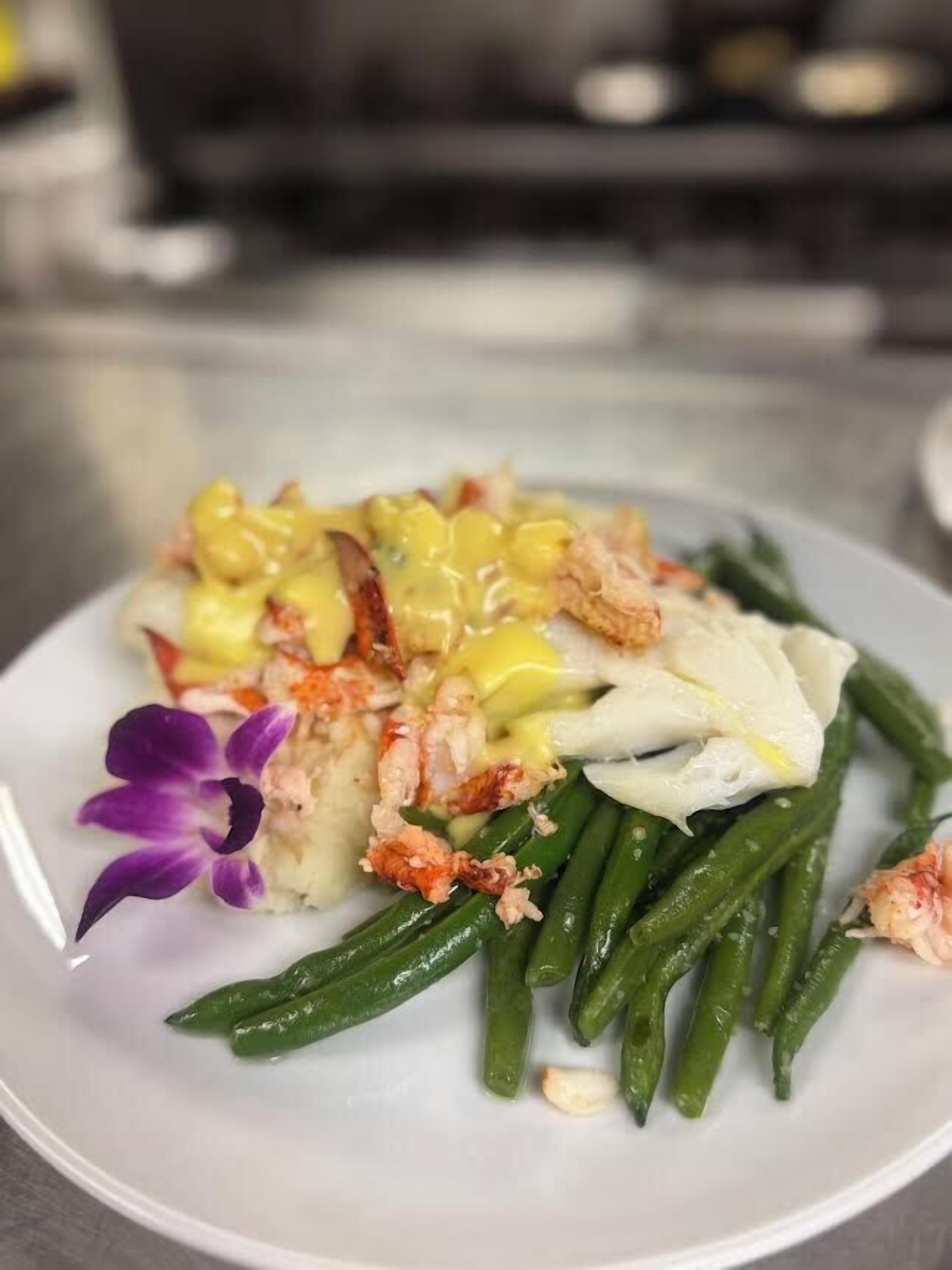 Un plato con mariscos, judías verdes y una flor.