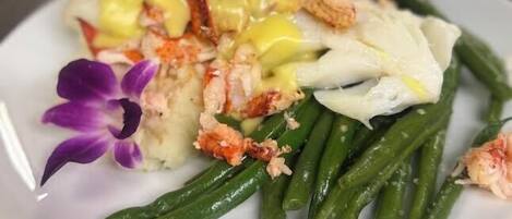 Un plato con mariscos, judías verdes y una flor.