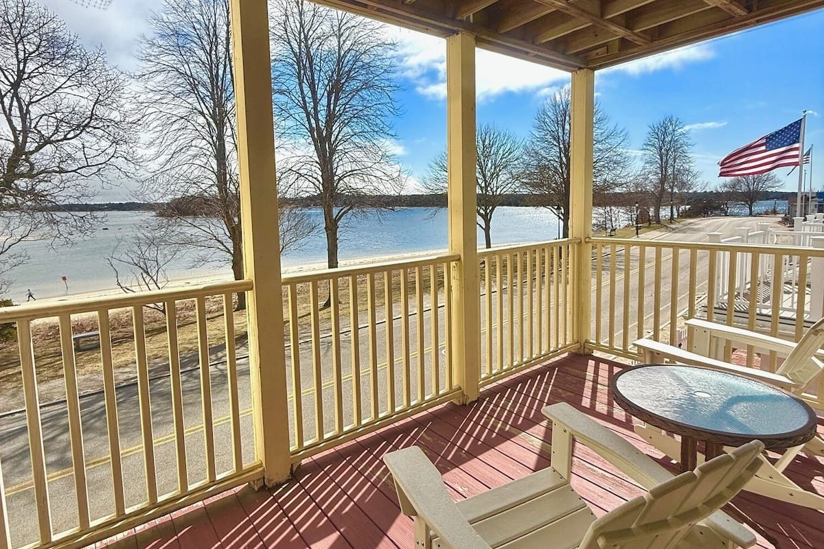 Ein überdachter Außenbereich mit einer Holzterrasse, einem Tisch und Stühlen.