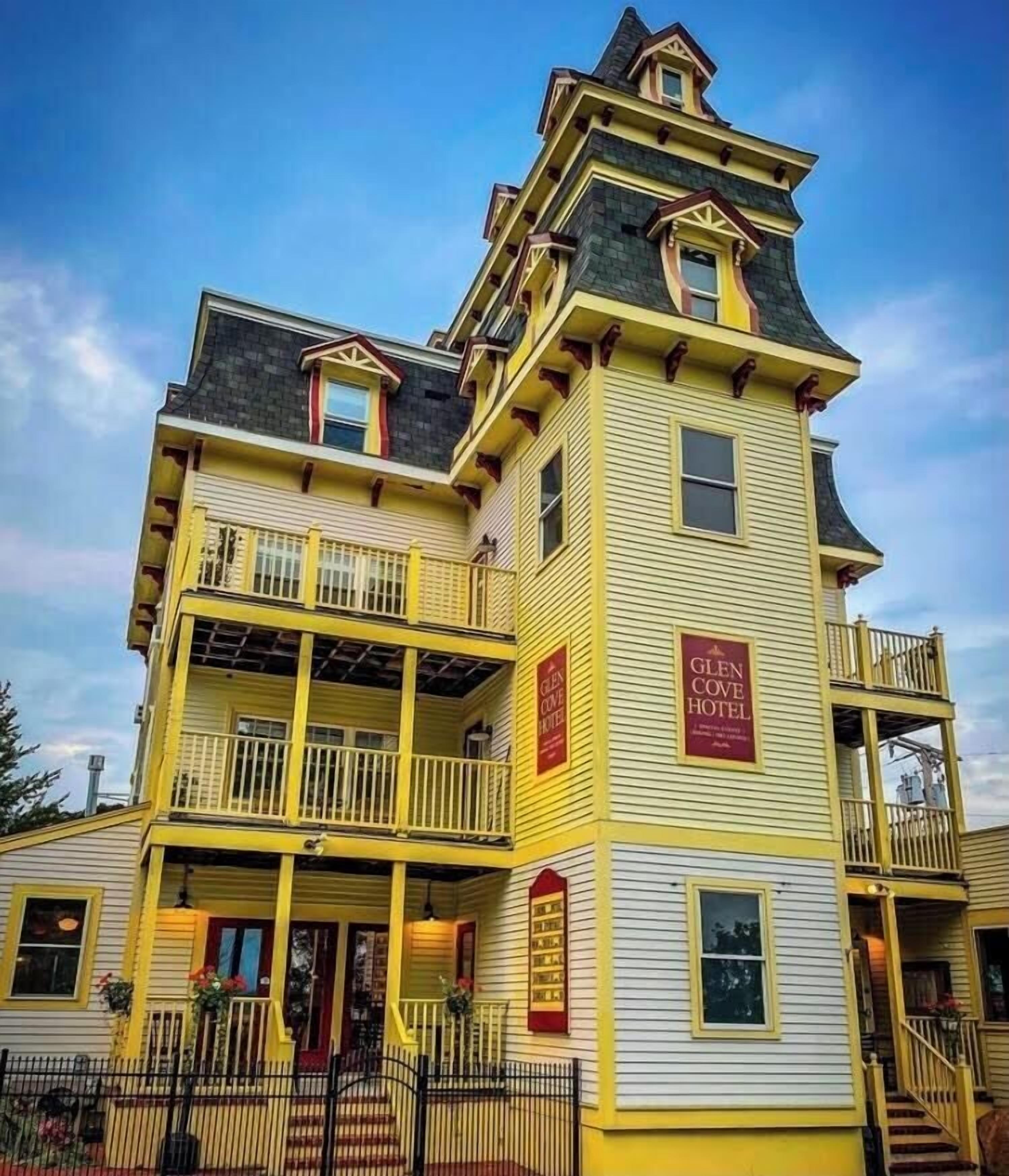 A multi-story hotel with yellow and white exterior walls, balconies, and a sign indicating it is the Glen Cove Hotel.