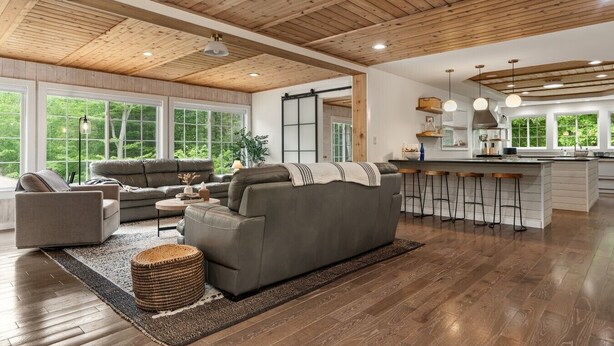 A spacious living area with a large gray sofa, a coffee table, and a bar area with stools. - Woodland Retreat at Fair Hill- Hot Tub, Pool, and Sport Court (Elkton)