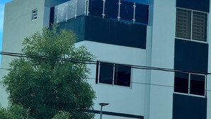 Een modern gebouw met een blauw dak en een heldere lucht.