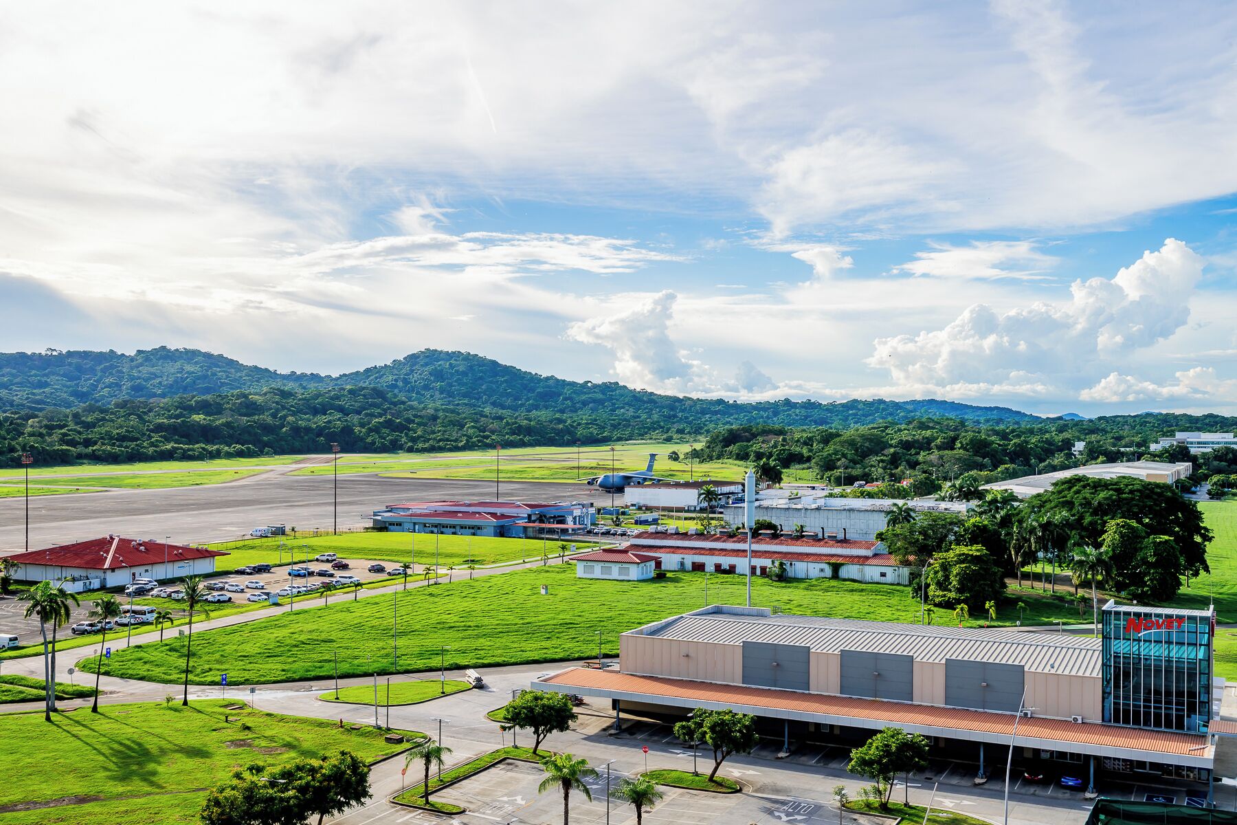 A large industrial area with multiple buildings, a parking lot, and a runway.