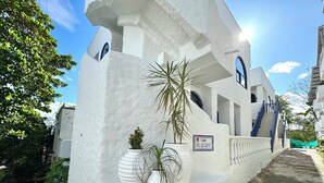 A white building with a sign reading "Calle Del Quijote." - Villa Kalah (Puerto Triunfo)