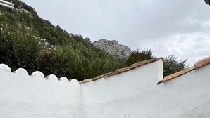 A rooftop terrace with white furniture, including two chairs and a table, set on artificial green grass. - La Cuadra. Peace and tranquility in a privileged rural setting (Villaluenga del Rosario)