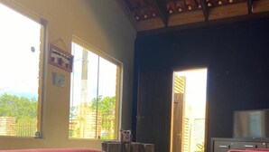 A spacious room with large windows, a wooden ceiling, and a red sofa. - POUSADA PEQUIZEIRO (Chapada dos Guimarães)