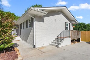 A single-story house with a front porch, a wooden deck, and a fenced backyard. - Horseshoes, Fire Pit, HOT TUB, Xbox Series S, Grill Outside (Greensboro)